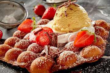 Bubble waffle topped with fresh strawberries cream and ice-cream
