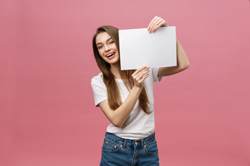 Close up portrait of positive laughing woman smiling and holding white big mockup poster isolated...