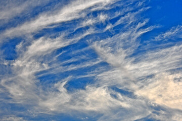 The high-level Wind streams cirrus clouds in different directions - obrazy, fototapety, plakaty