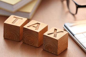 Cubes with word TAX on table