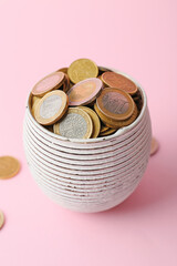 Bowl with golden coins on color background