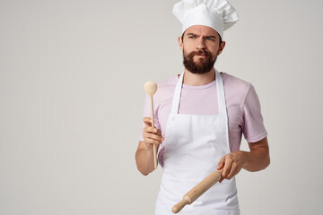 Naklejka premium professional chef in uniform with a spoon in his hands work light background