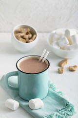 Fototapeta na wymiar Cup of hot cocoa drink and marshmallows on light background