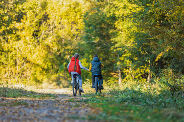 Obraz premium children ride a bike near the forest holding hands