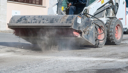Sweeper attachments mini excavator. The sweeper sweeps, collects and dumps dirt and debris.