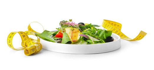 Plate with healthy salad and measuring tape on white background