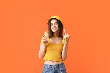 Beautiful young woman with fresh lemonade on color background