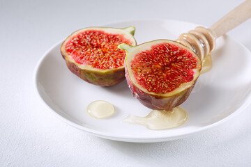 figs cut into pieces and drizzled with honey on a white plate.