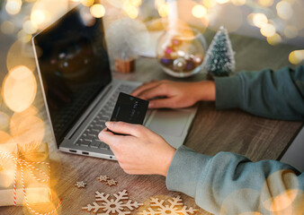 Christmas online shopping for gifts, laptop, credit card and New Year decorations on the table