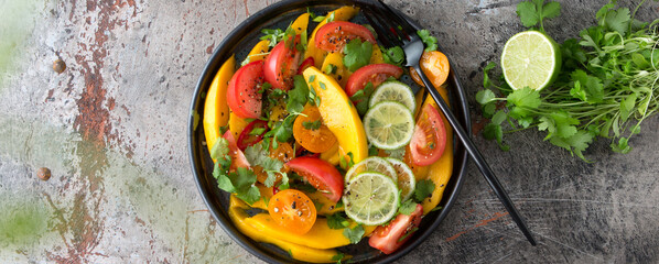 flat lay plate of salad with mango and tomato on the table