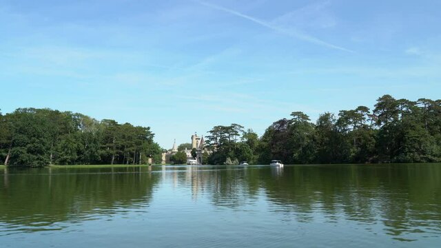 A footage of a fairytale castle on the island. View from a boat floating on the lake.