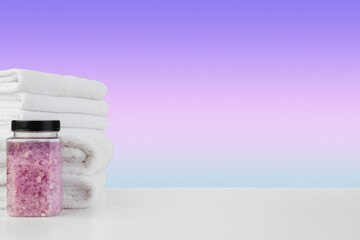 Obraz na płótnie Canvas Bath towels and spa salt on white table
