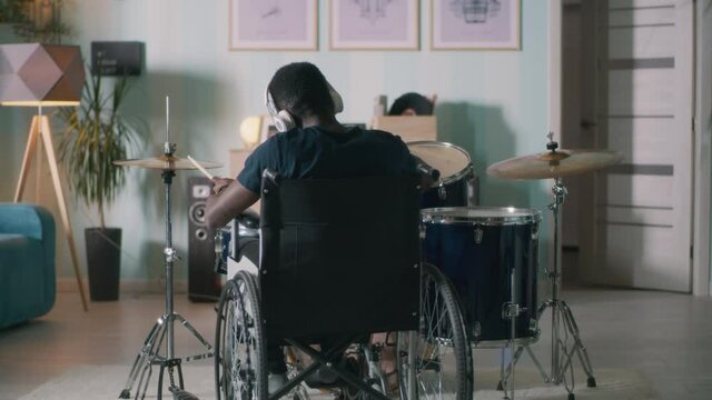 Unrecognizable handicapped drummer in home studio