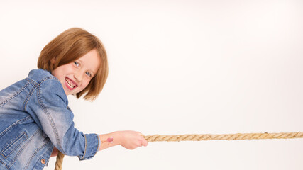 Portrait kleines Mädchen zieht fröhlich an einem Seil, weißer Hintergrund Vs4