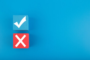 True and false symbol on blue and red cubes against bright blue background with copy space