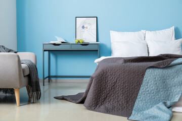 Bedroom with comfy double bed and bedside table near color wall