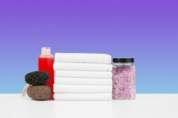 Bath towels and spa salt on white table