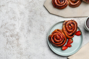 Plate with tasty strawberry buns on light background