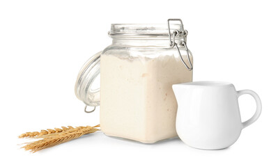 Jar and jug with fresh sourdough on white background
