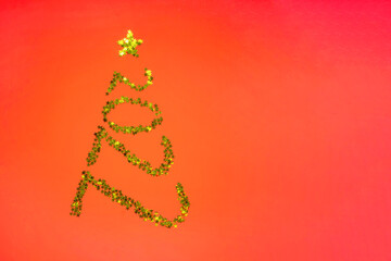 Christmas tree geometric in shape numbers 2022 from gold stars spangles on red background. Christmas new year holiday winter concept. Copy space. Template of greeting card