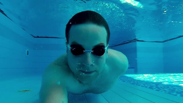Man Swimming Underwater On Sunny Swimming Pool
