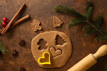Gingerbread dough is rolled out. There is a heart-shaped cutter on it. A gingerbread man, a...
