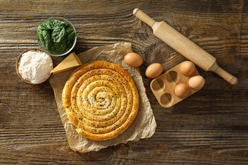 Composition with tasty spinach pie on wooden background