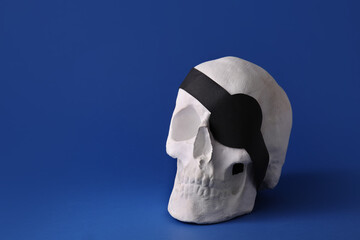 Pirate skull with eye patch on color background