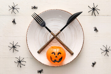 Halloween table setting with spiders on white wooden background