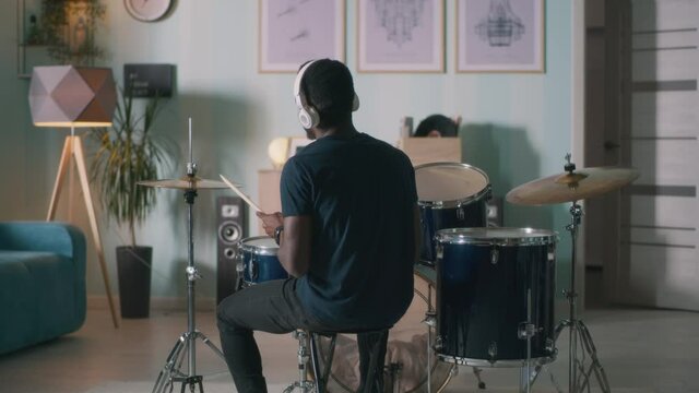 Black drummer rehearsing at home