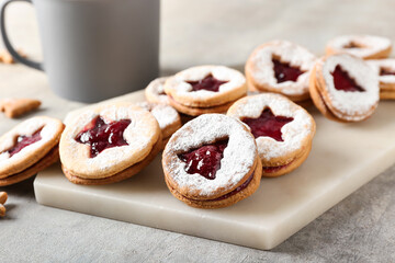 Board with tasty Linzer cookies on grunge background