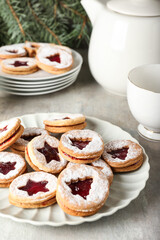 Plate with tasty Linzer cookies on grunge background