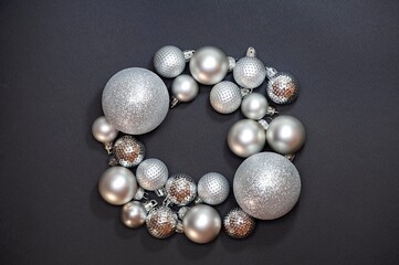 Christmas composition of silver balls. Christmas wreath on a black background. Flat lay, top view
