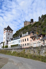 Fototapeta na wymiar Promenade mit weißem Turm von Sankt Goarshausen mit Burg Katz darüber