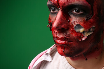 Scary zombie man on color background, closeup