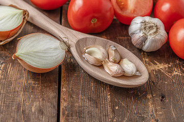 vegetables for the eggplant saute: eggplant, tomatoes, onions and garlic on a wooden table