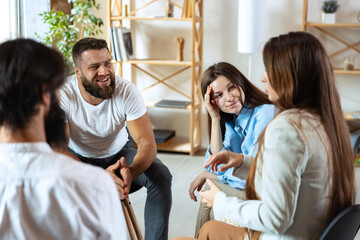 Obraz premium Young multiethnic people, men and woman sitting together, talking, communicate at psychological support group, indoors.
