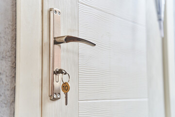 A key with a key fob in the keyhole of the door. Buy a new home concept. Real estate market. High quality photo