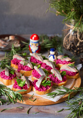 Sandwiches with beets and herring. New Year's snack with fish. Christmas food. Appetizing on New...