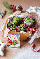 Christmas muffins with mint and cranberries. Chocolate cupcakes for the New Year. A gift box with sweets. Christmas food styling. New Year's festive atmosphere and delicious pastries