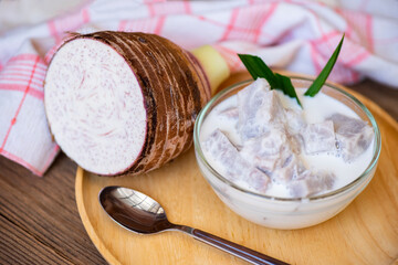 Taro food with dessert taro boiled with sugar and coconut milk on bowl and fresh raw organic taro root ready to cook, Asian Thai food