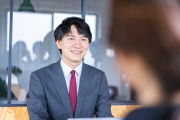 会議で発言をする若いビジネスマン