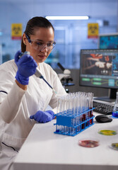 Chemist researcher dropping liquid in medical glassware using micropipette analyzing coronavirus...