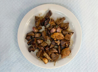 Fried lamb liver pieces and sliced lamb lung on a white plate