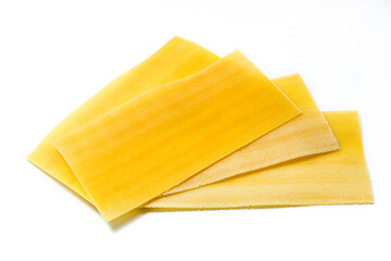 Uncooked raw lasagna pasta isolated on white background. Stack of dried uncooked lasagna 

pasta sheets - obrazy, fototapety, plakaty