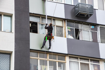 Facade worker plastering external wall of building