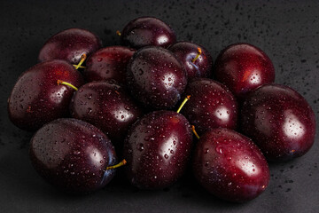 Fresh organic plums on dark background