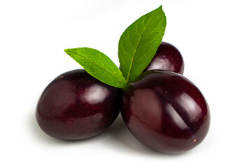 Plums with plum leaves on a white background.