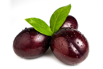 Plums with plum leaves and water drops on a white background.