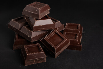 Pieces of dark chocolate on a dark background